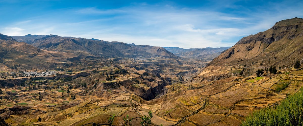 A mountainous landscape with terraced fields and a small settlement.