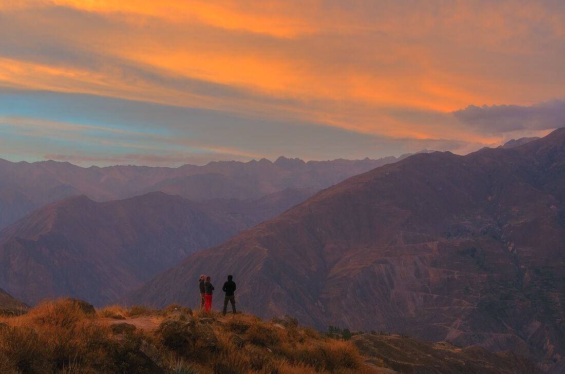 Un paisaje montañoso con un atardecer.