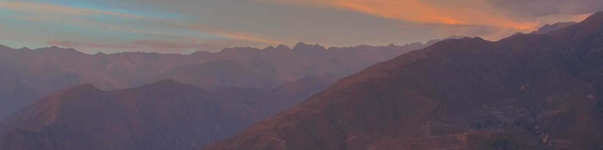 Un paisaje montañoso con un atardecer.