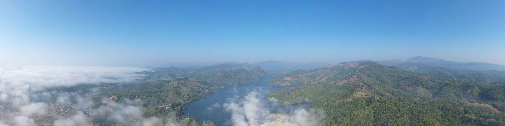 A mountainous landscape with a lake surrounded by forested areas.