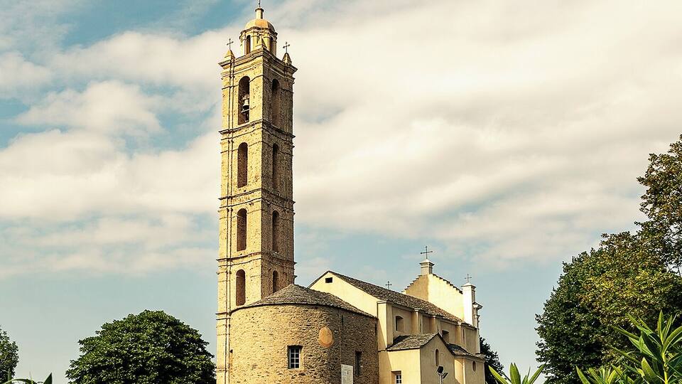 A historic church with a tall bell tower and a smaller building.