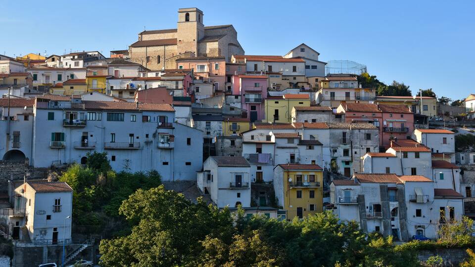 A hillside of colorful buildings with a prominent church tower.