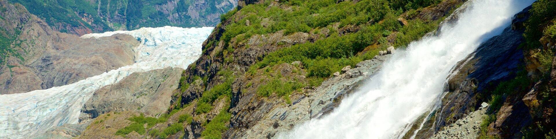 Un glaciar con una cascada deslizándose por una ladera rocosa.