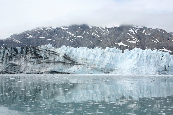 A glacier with a rocky mountain in the background.