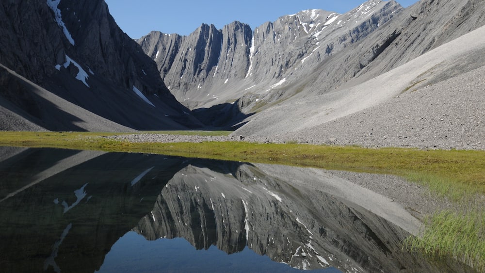 A mountain landscape with a lake reflecting the peaks.
