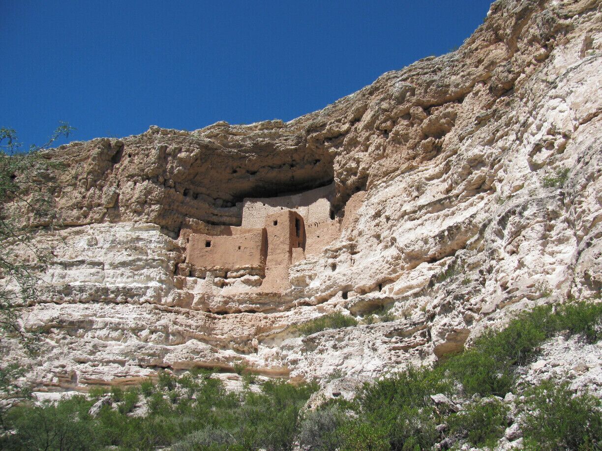 A cliffside with ancient ruins carved into the rock.
