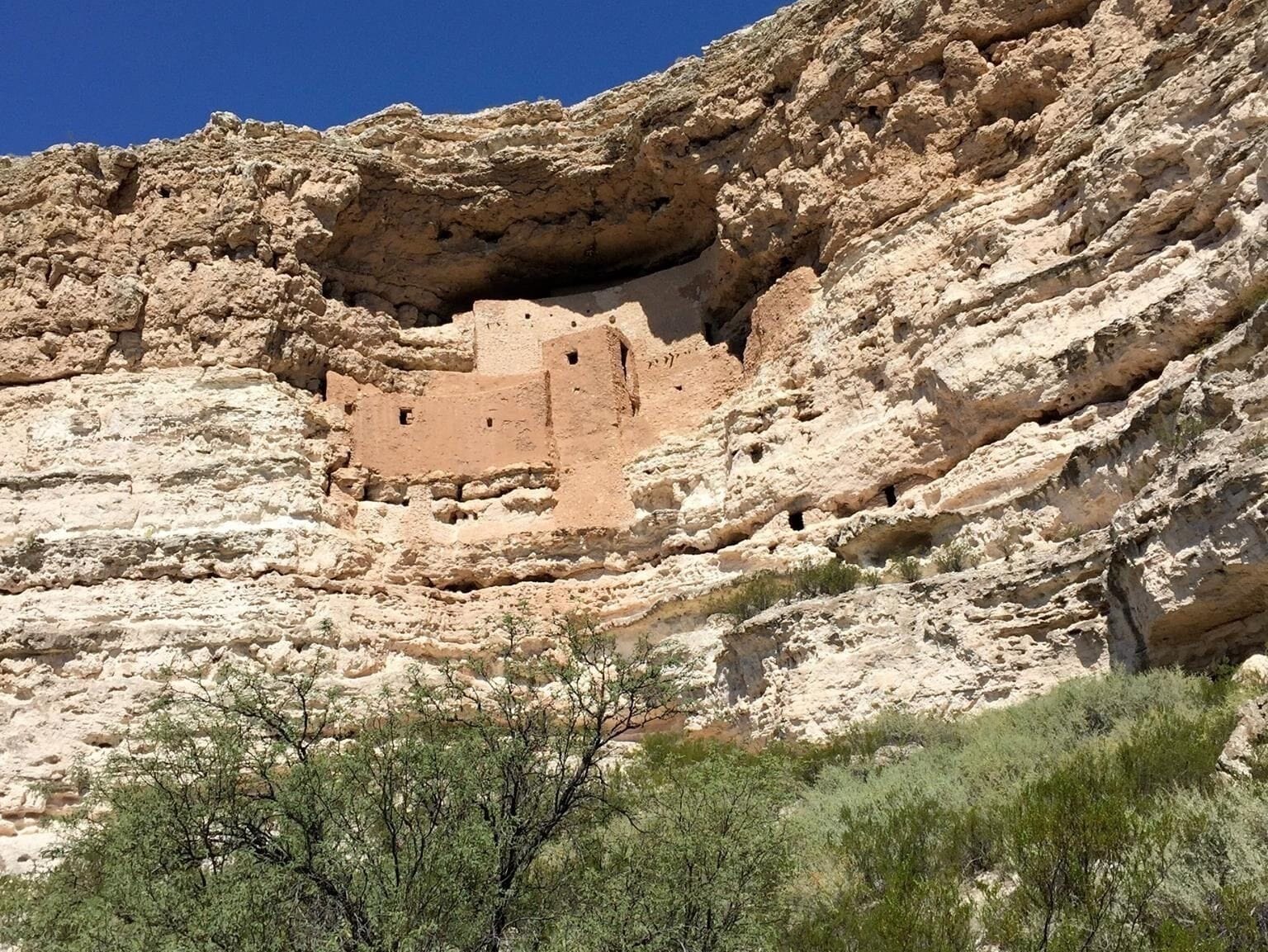 A cliffside with ancient ruins carved into the rock.