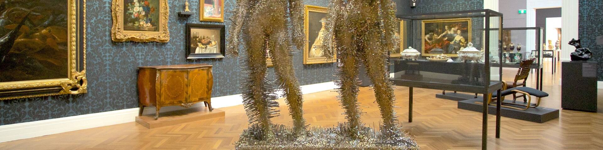 Una galería de arte con pinturas y esculturas ornamentadas.