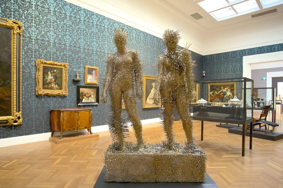 An art gallery with ornate paintings and sculptures.