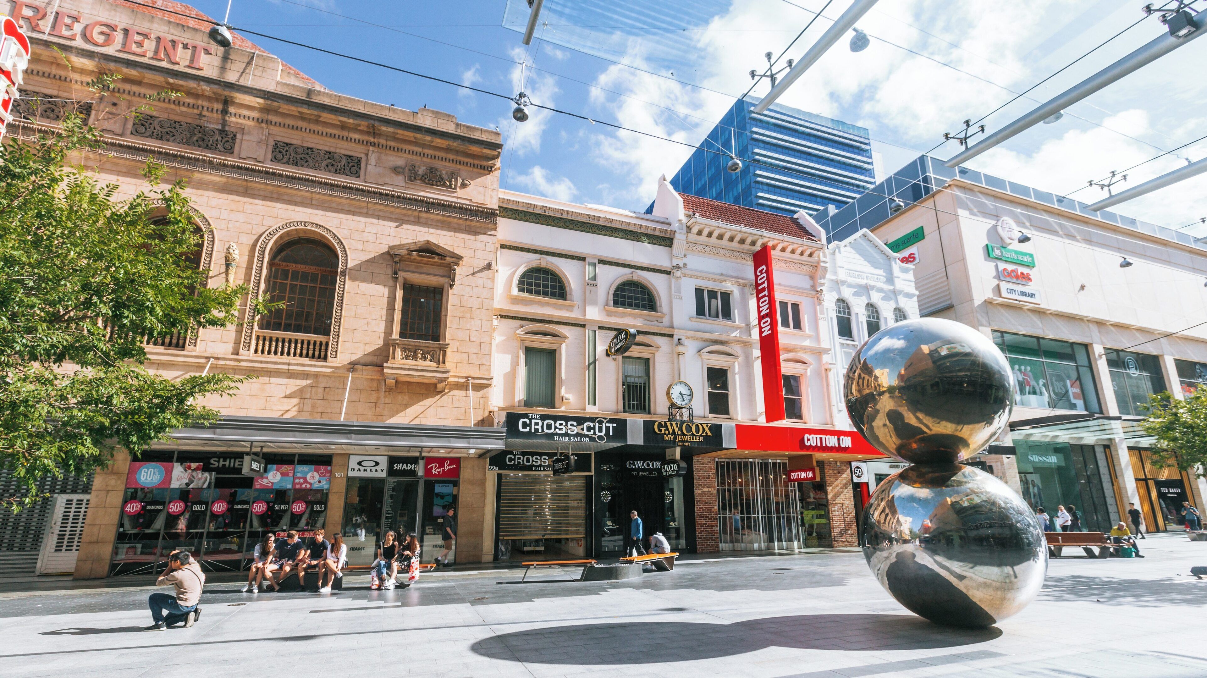 Exploring Rundle Mall in Adelaide Central Business District with shoppers and unique sculptures on a sunny day