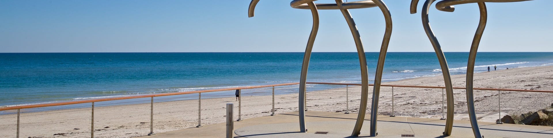 A beach with metal sculptures and a clear blue sky.