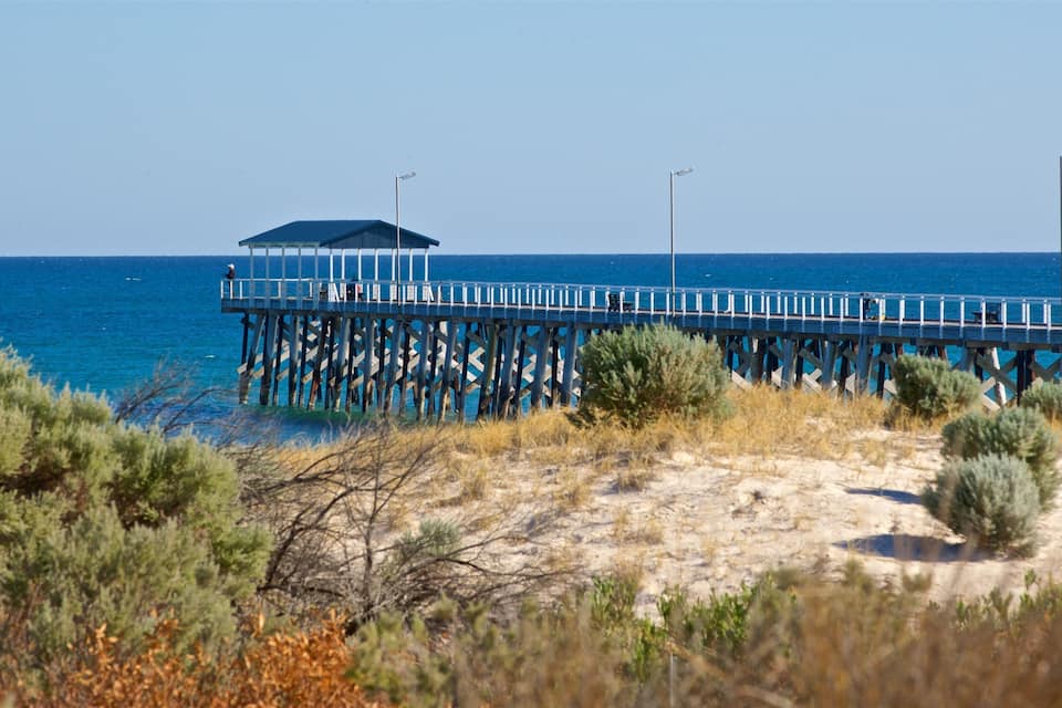 A pier extending into the sea with a covered area at the end.