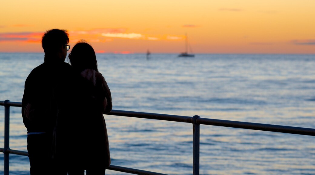 Glenelg Beach which includes a sunset, general coastal views and views