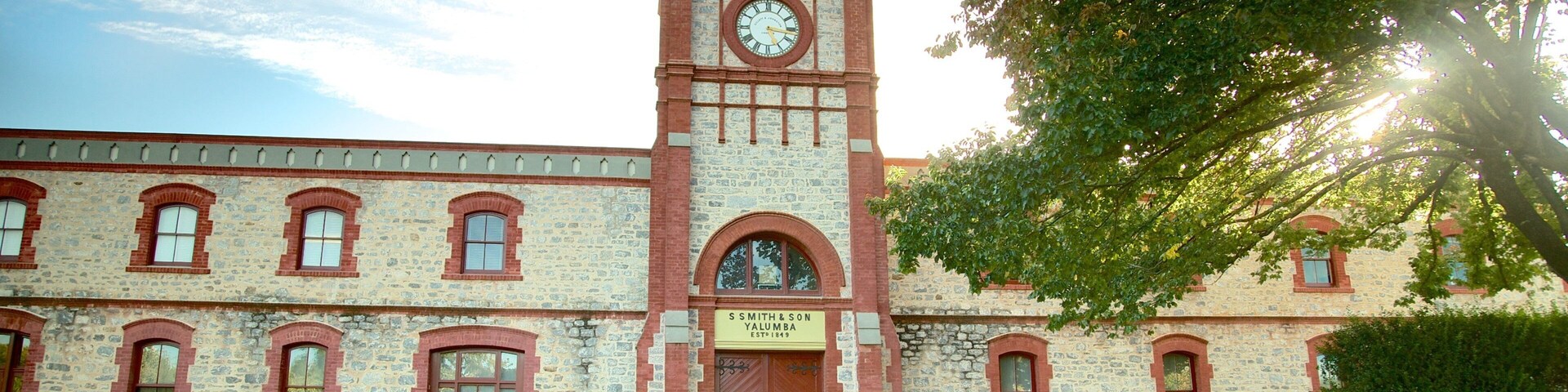 A historic building with a clock tower, stone facade, and a sign reading "S. S. Smith & Son Yalumba Established 1849".