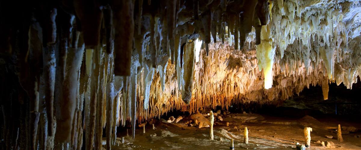 A cave with stalactites hanging from the ceiling and stalagmites on the ground.