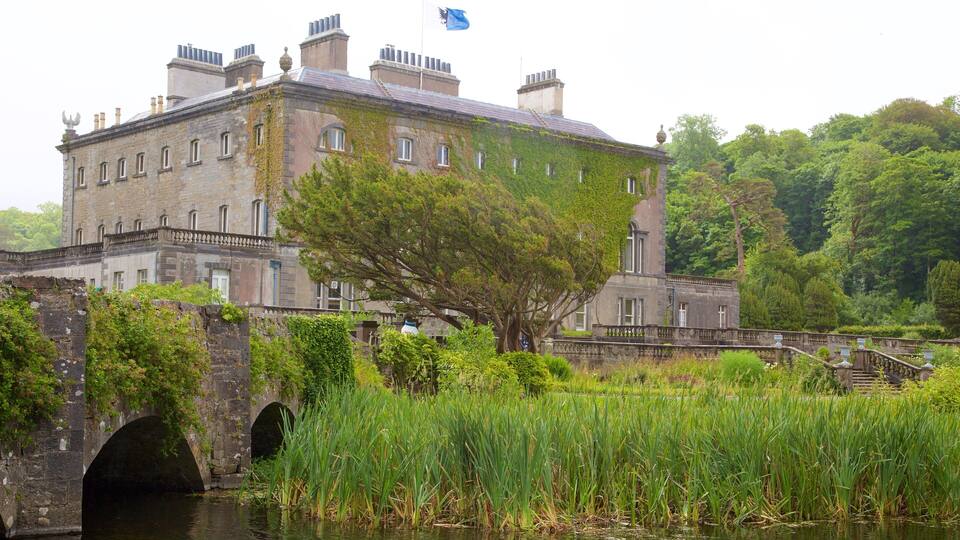A historic stone building with ivy, a bridge, and a river.
