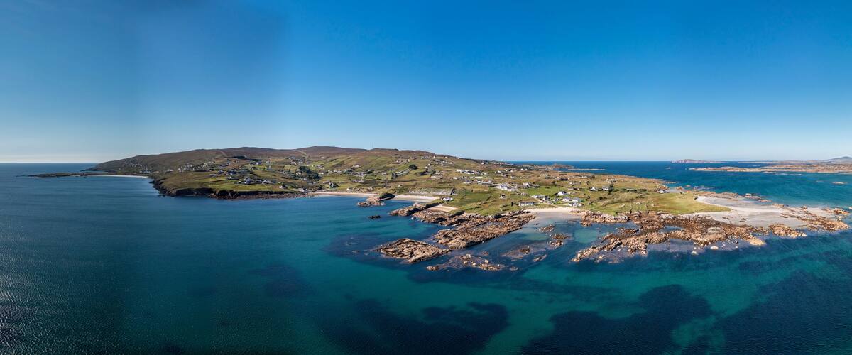A coastal landscape with a small island, rocky outcrops, and a lighthouse.