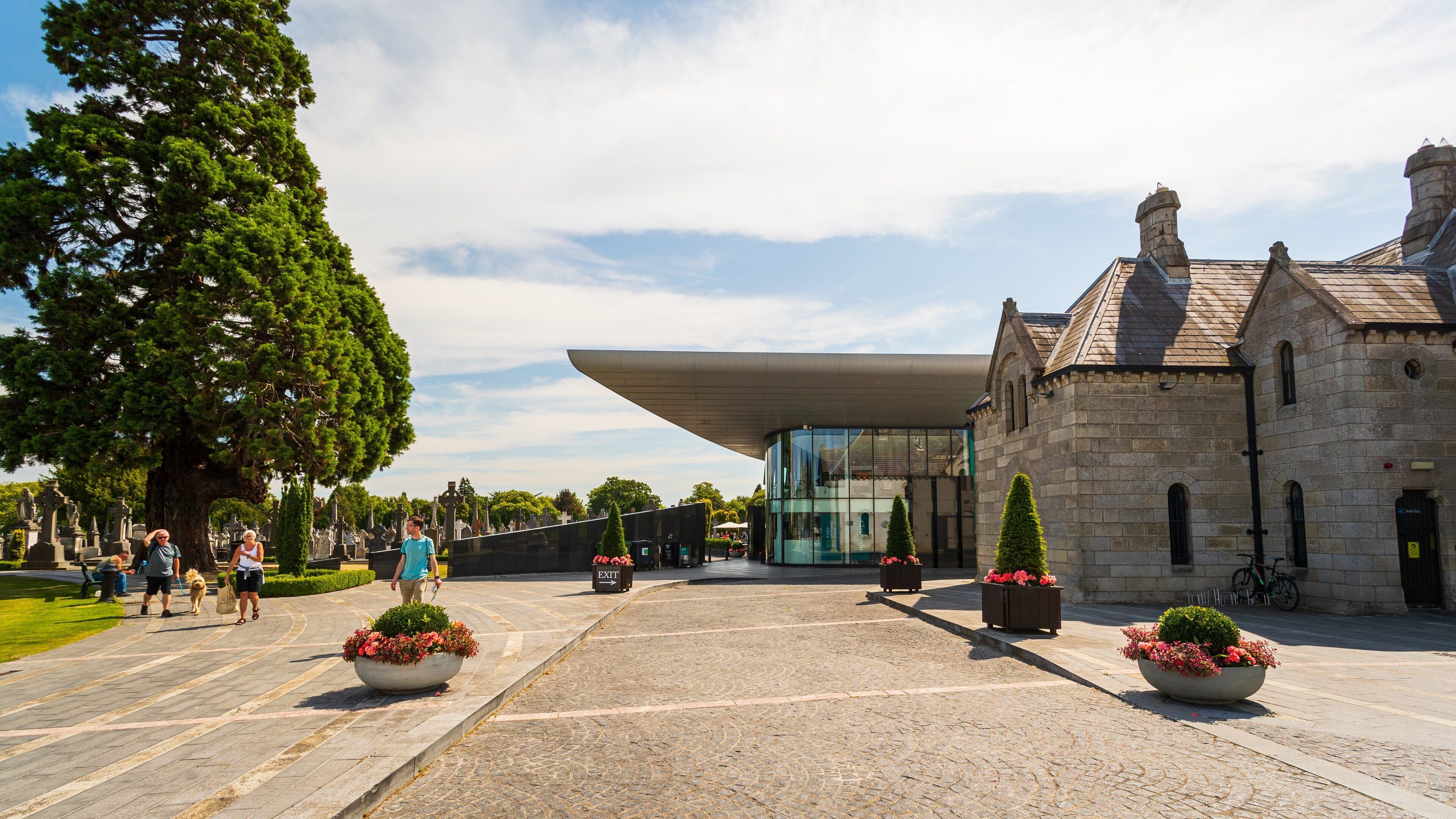 A cemetery with a modern building and stone structures.
