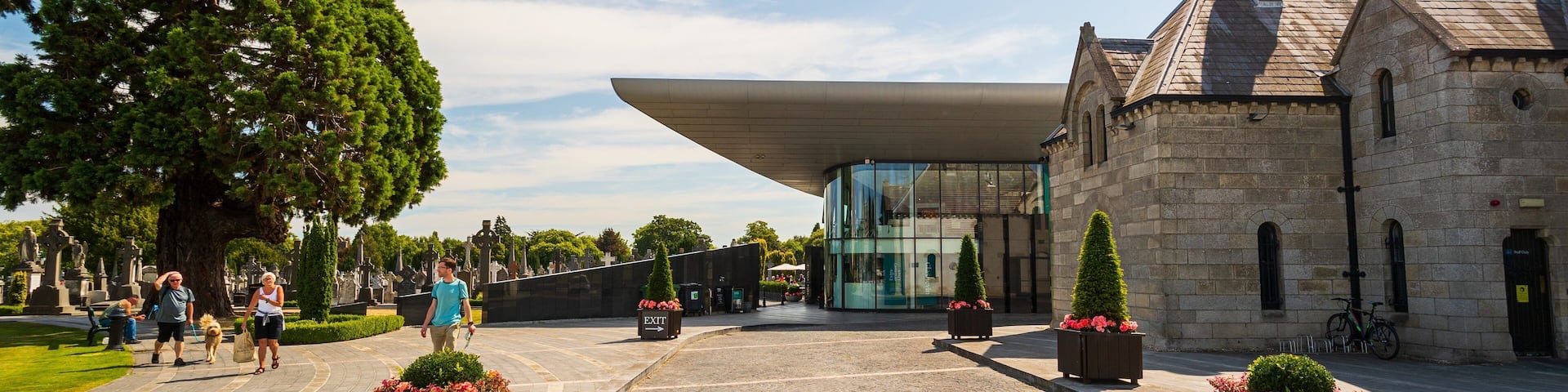 A cemetery with a modern building and stone structures.