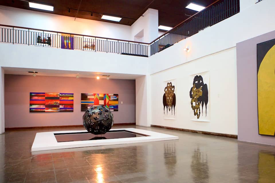 An art gallery with abstract paintings and sculptures.