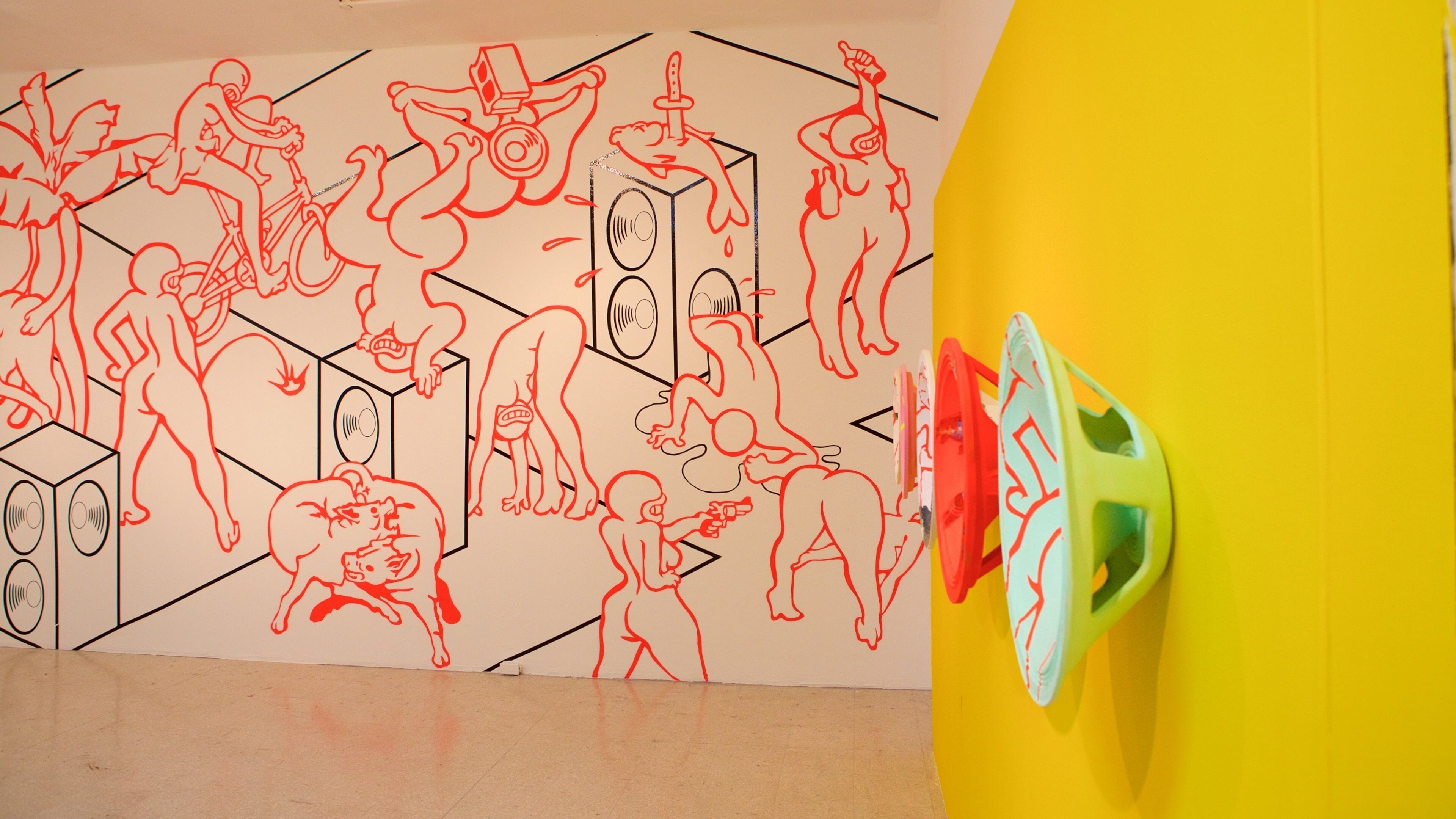 Een muur met rode lijntekeningen van verschillende figuren en objecten, waaronder een gele structuur met groene en rode accenten.