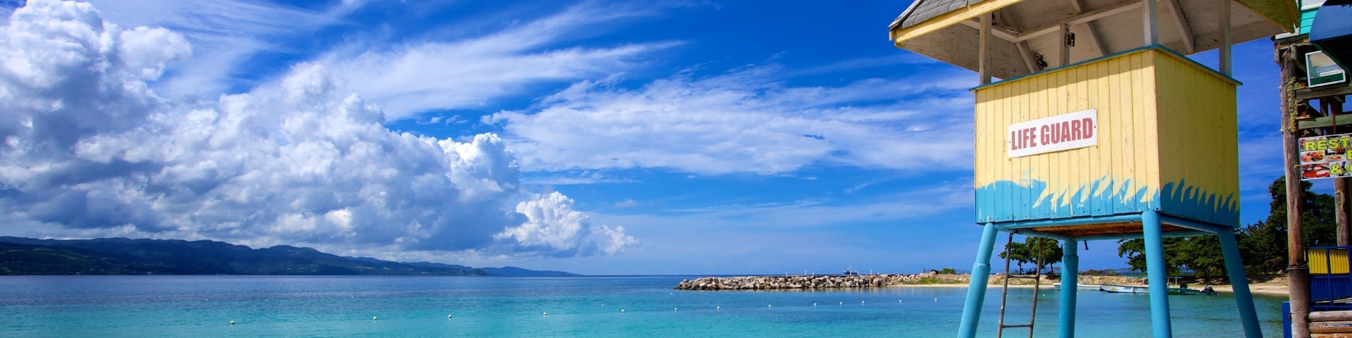 Parque temático AquaSol que incluye vistas de una costa y una playa de arena