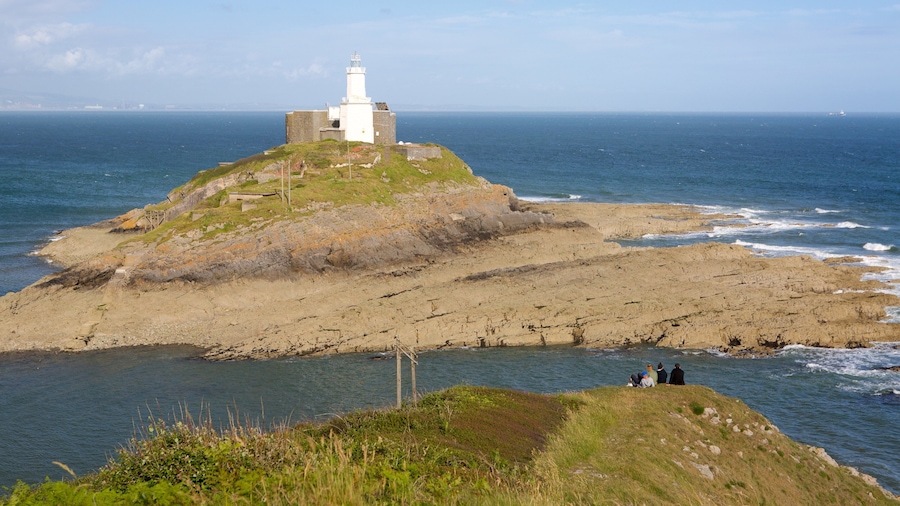 A white lighthouse on a rocky island with a sea view.