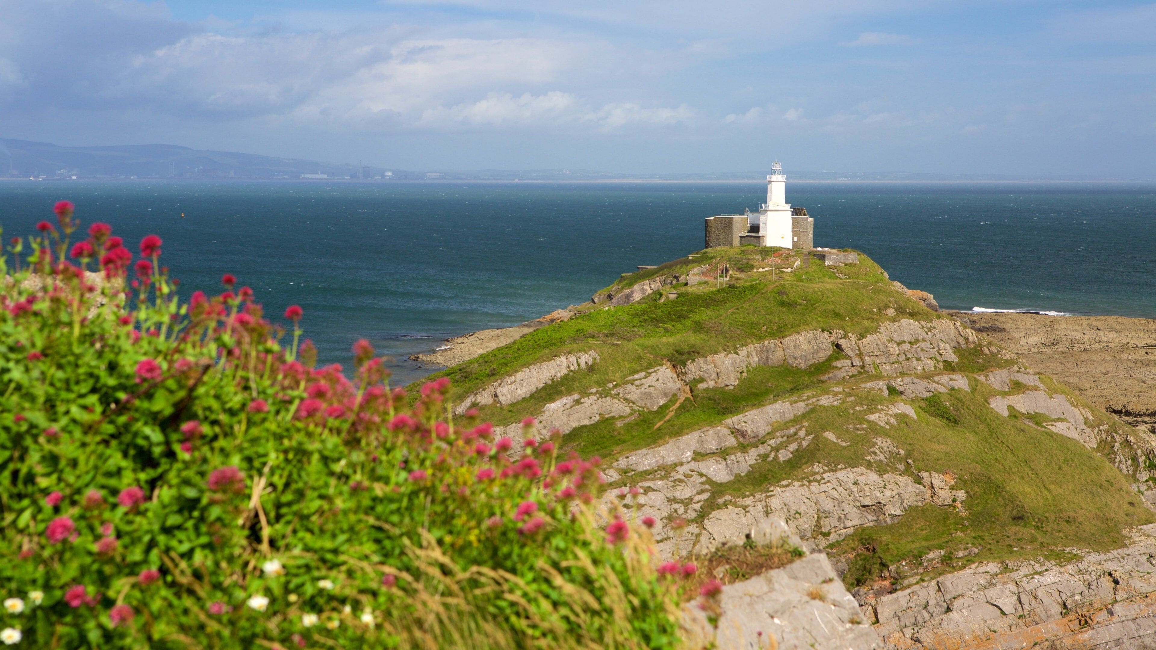 Mumbles Lighthouse showing mountains, general coastal views and a lighthouse