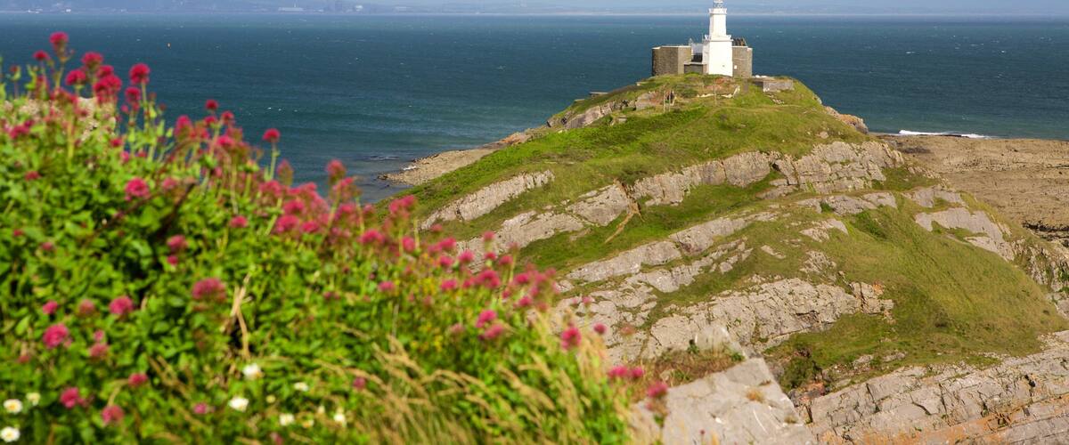 Mumbles Lighthouse showing mountains, general coastal views and a lighthouse