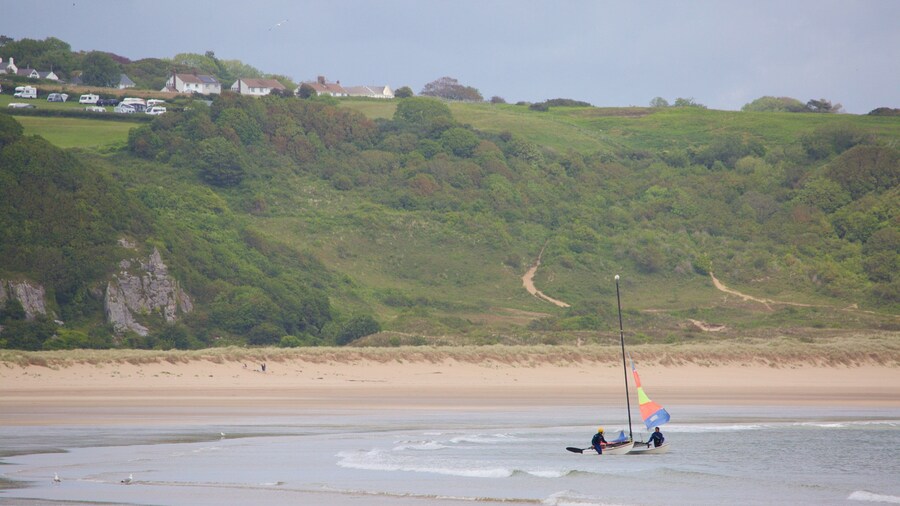 Oxwich Bay Beach som omfatter en strand og en bugt eller havn