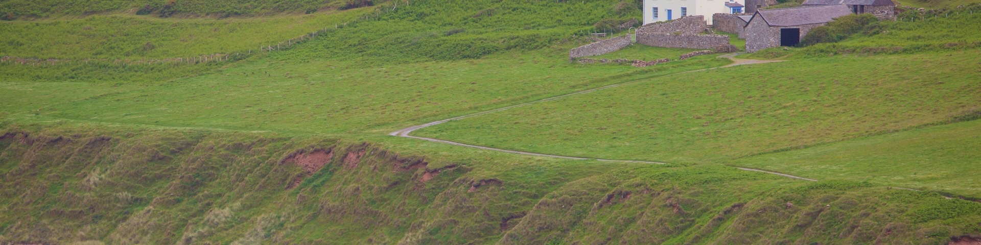 Rhossili Beach featuring a sandy beach, farmland and a house