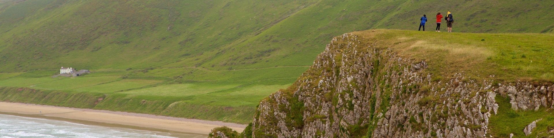 Praia de Rhossili caracterizando uma praia de areia, montanhas e paisagens litorâneas