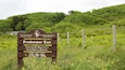 A sign for Freshwater East, Pembrokeshire Coast National Park, and Gwrchodfa Natur Leol Local Nature Reserve.