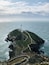 A lighthouse on a rocky island surrounded by the ocean.