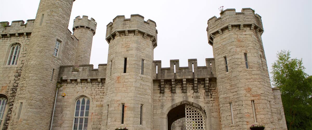 A historic castle with two prominent towers, arched windows, and a large entrance gate.