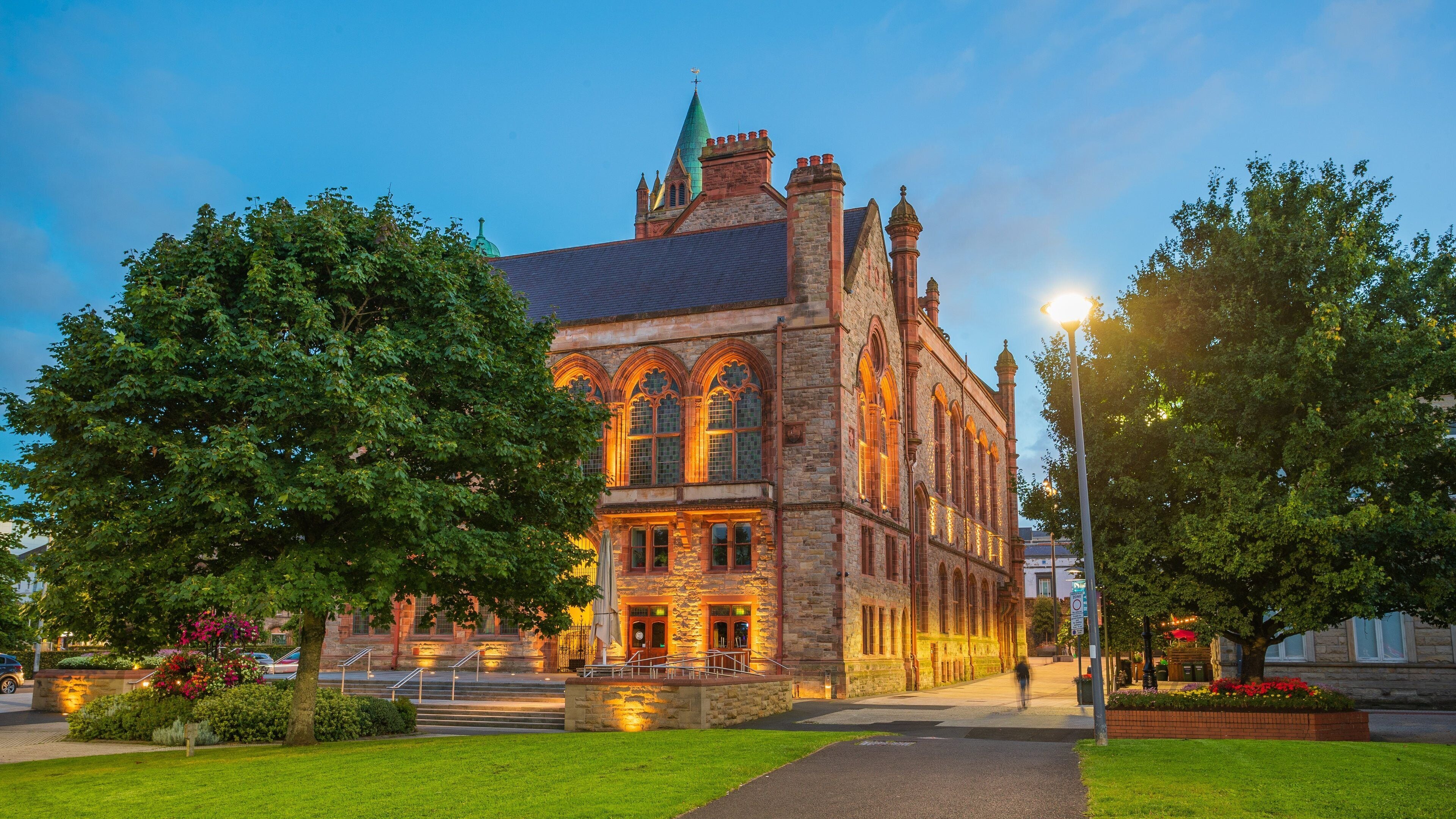 A historic building with arched windows and a green spire.