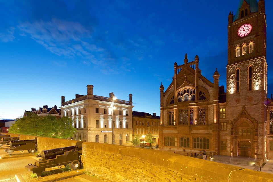 A historic building with a clock tower and a bridge.