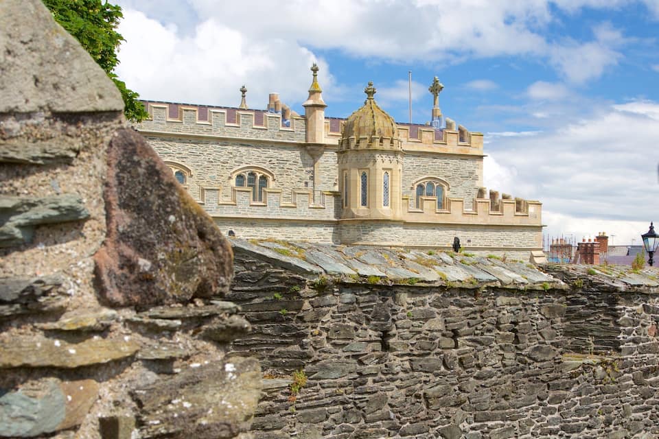 A historic stone building with arched windows and a tower.