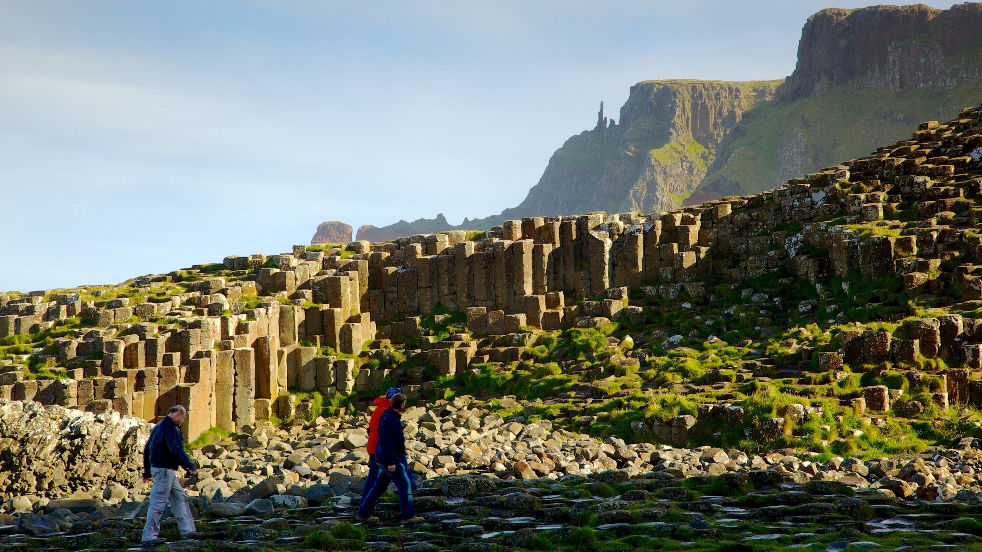 Giant\'s Causeway featuring a gorge or canyon and hiking or walking as well as a small group of people