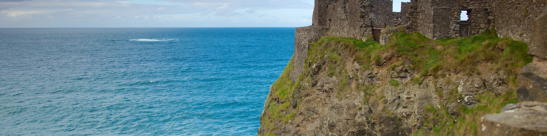 Dunluce Castle which includes a castle, building ruins and rocky coastline