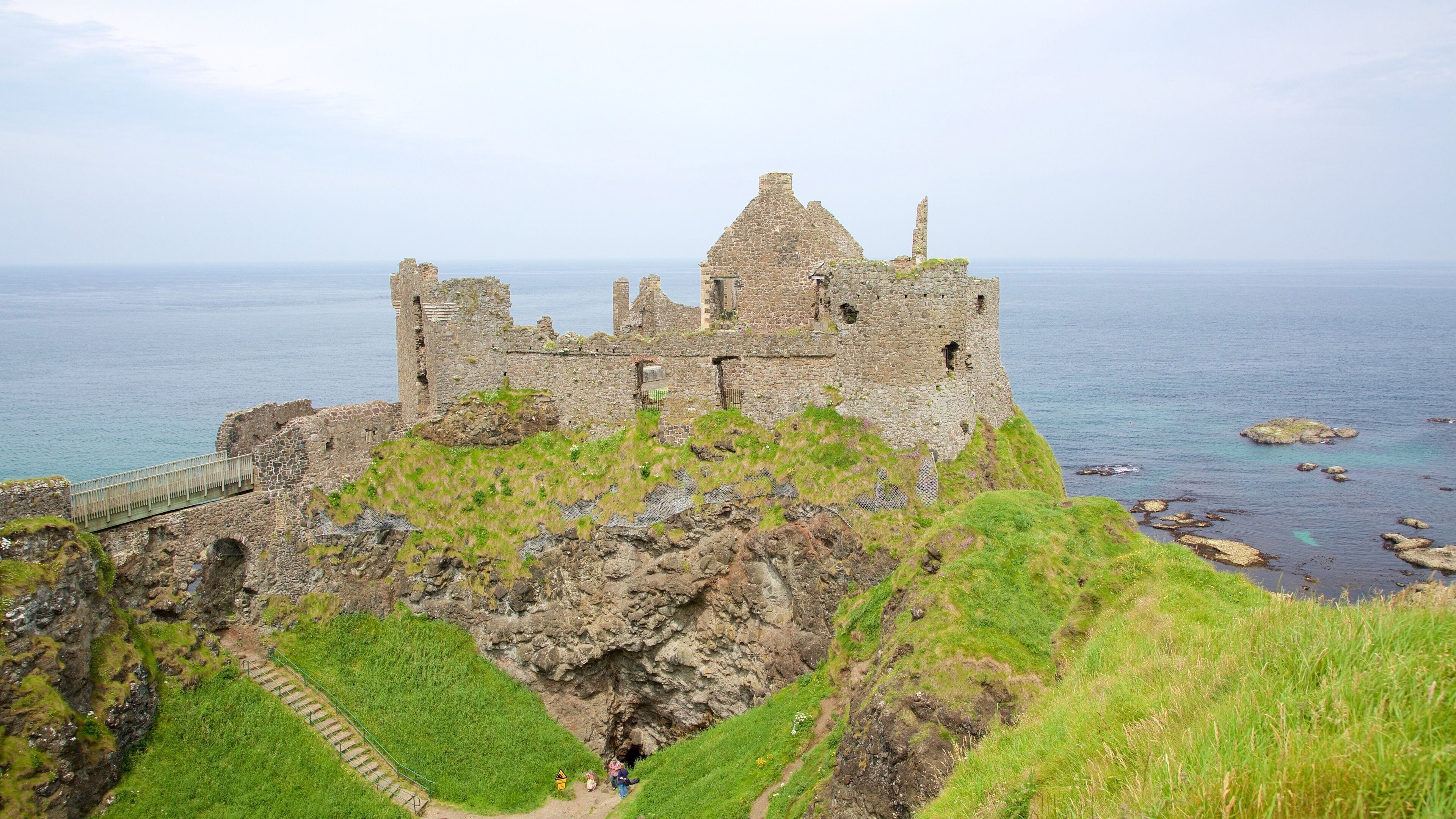 A historic stone castle on a cliff overlooking the sea.