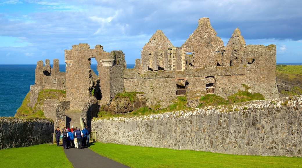 Dunluce Castle som inkluderer bygningsruiner og kulturarv i tillegg til en liten gruppe med mennesker