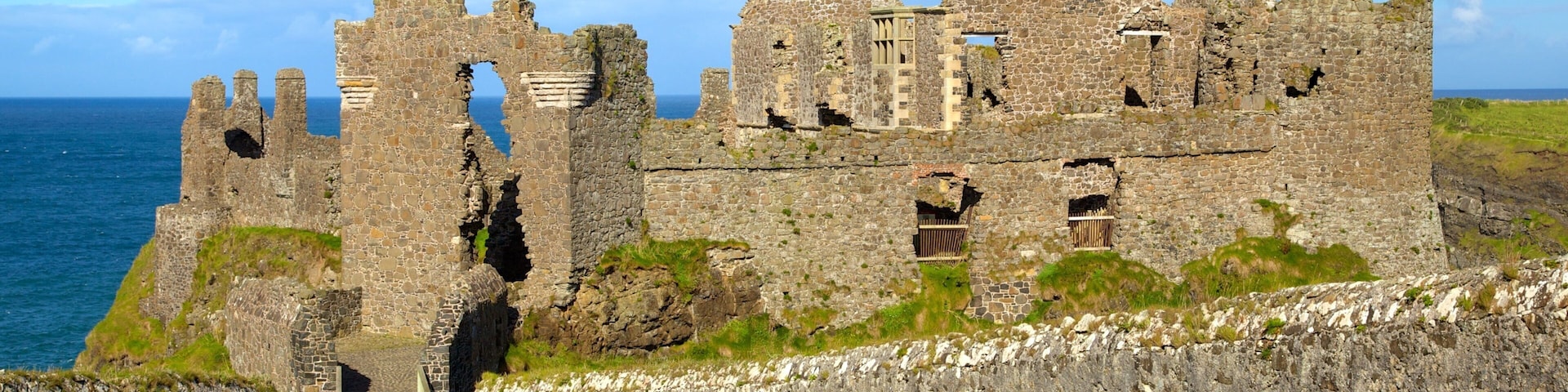 Dunluce Castle which includes heritage elements and a ruin as well as a small group of people