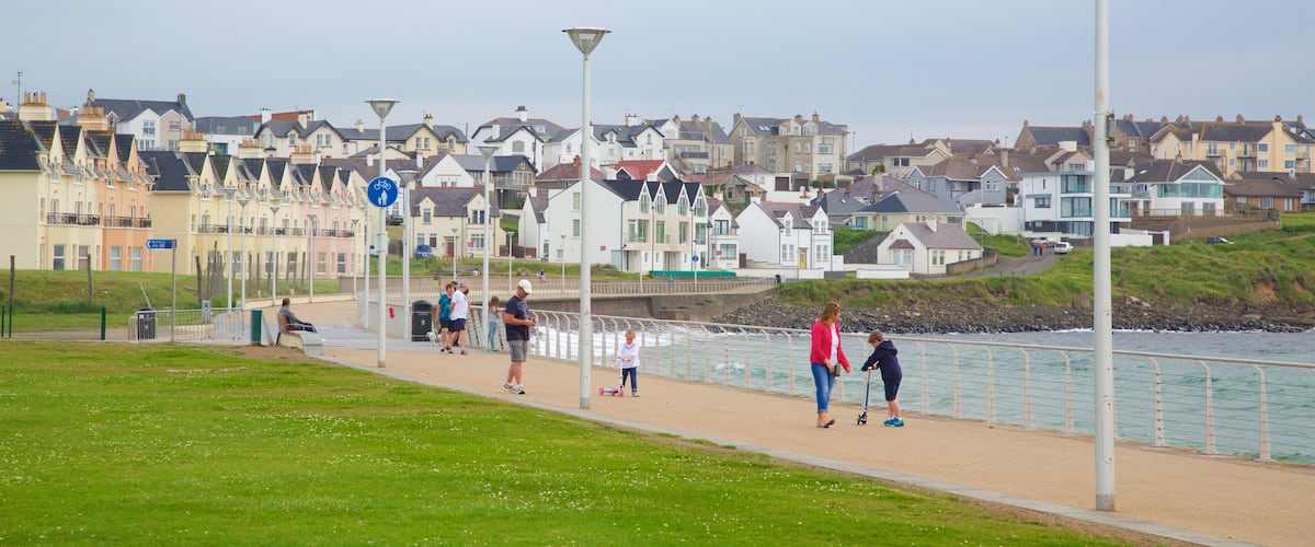 A coastal promenade with houses, a bike path, and a sea wall.