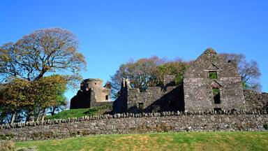 An ancient stone castle with a tower and a ruined wall.