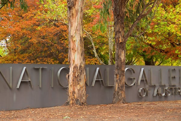 Une enseigne indiquant l’entrée de la Galerie nationale d’Australie, avec des arbres en arrière-plan.