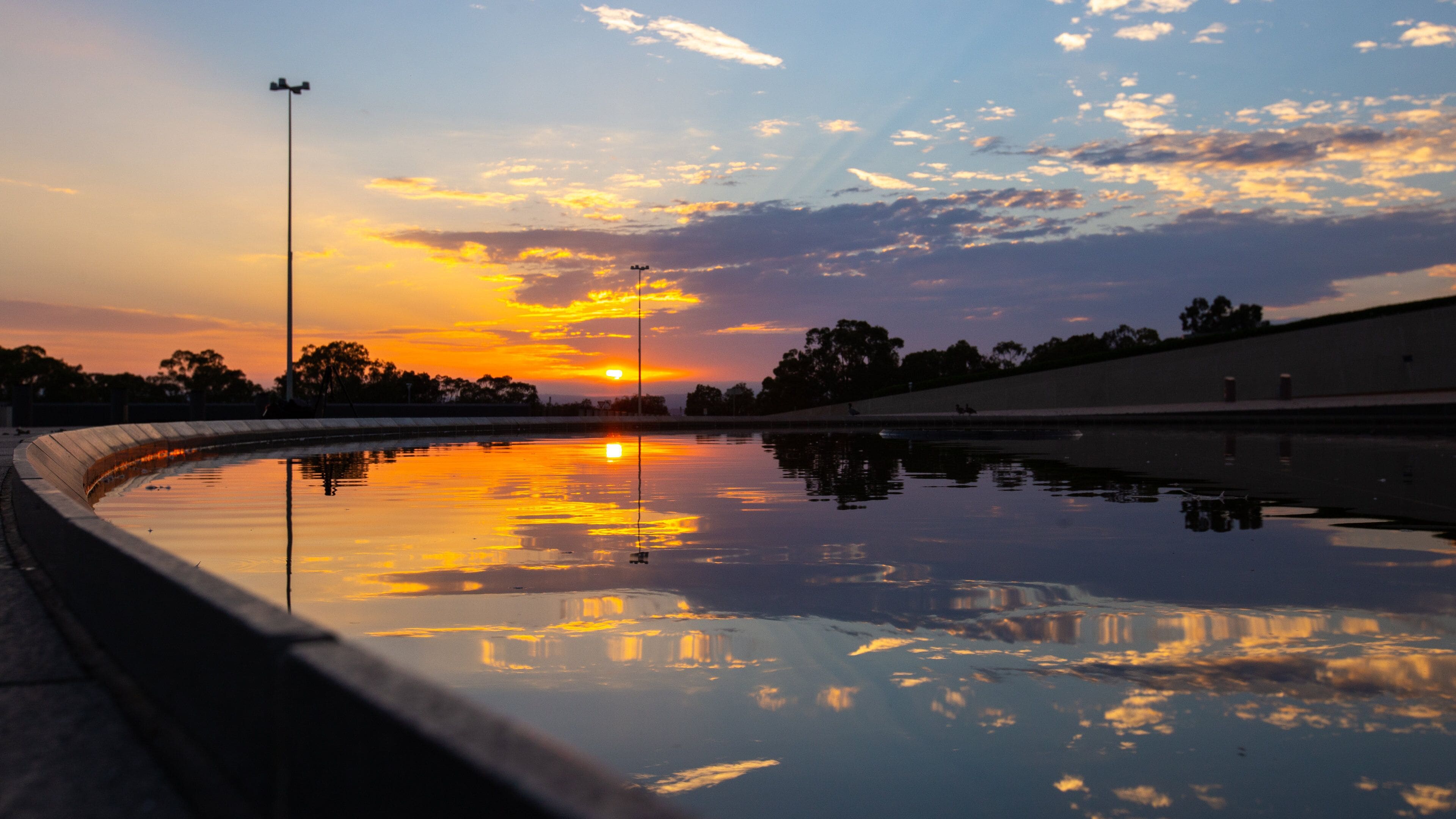 Parliament House featuring a river or creek and a sunset