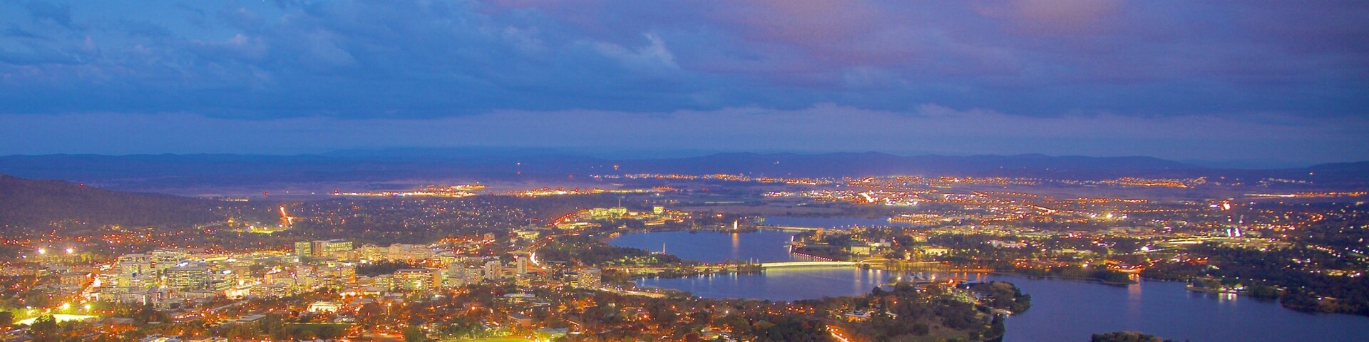 Telstra Tower which includes night scenes, a city and a lake or waterhole