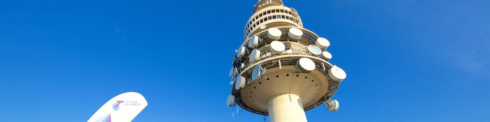 A tower with multiple antennas and a sign that reads "Welcome to Telstra Tower".
