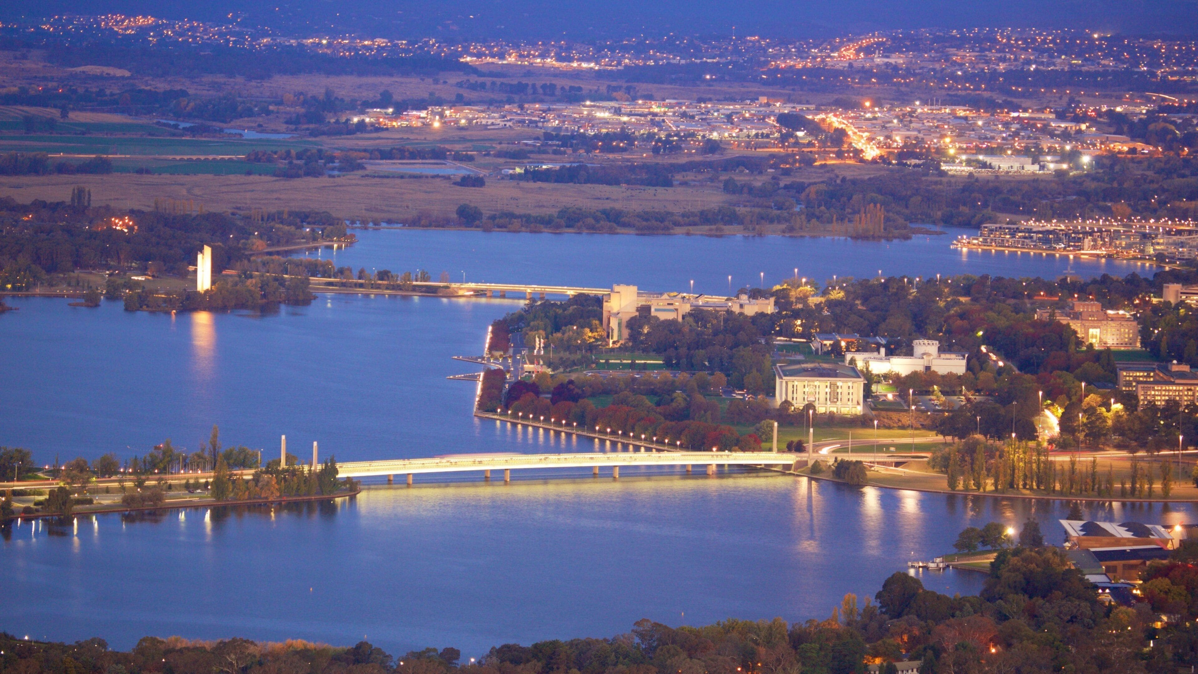 Telstra Tower som viser natteliv, en by og en sø eller et vandhul